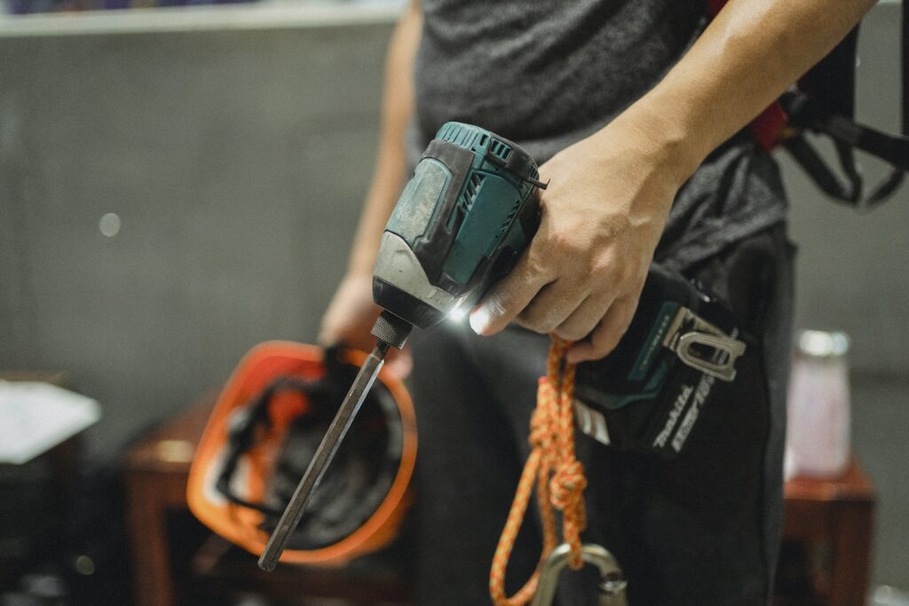 Crop repairman standing with working screwdriver and orange helmet