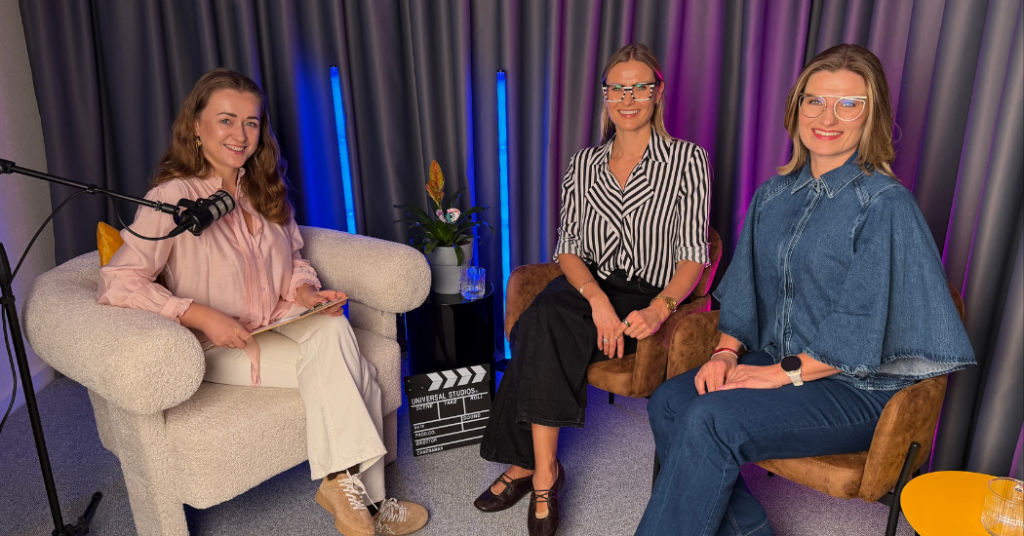 Trzy kobiety na spotkaniu w studio agencji marketingowej, dyskusja o strategiach SEO i social media.