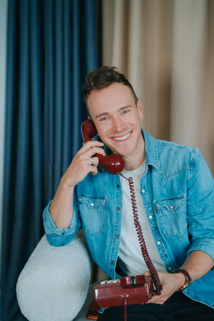 Reklama płatna Google Ads 12 Mężczyzna w dżinsowej koszuli rozmawiający przez telefon w biurze agencji marketingu internetowego.