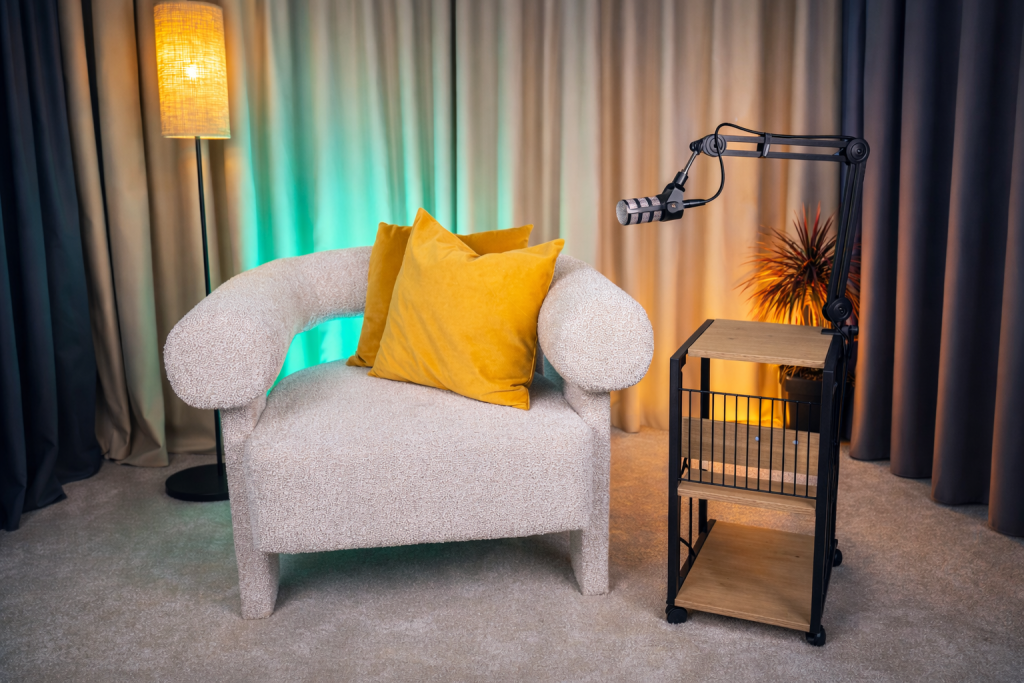 Fotel z żółtymi poduszkami i mikrofon w nowoczesnym pokoju, idealny do nagrywania wideo o marketingu internetowym.