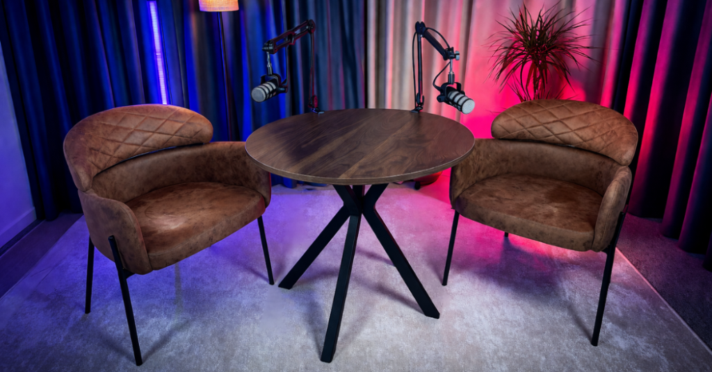 Studio nagrań z mikrofonami przy okrągłym stole, idealne do podcastów o marketingu i SEO.